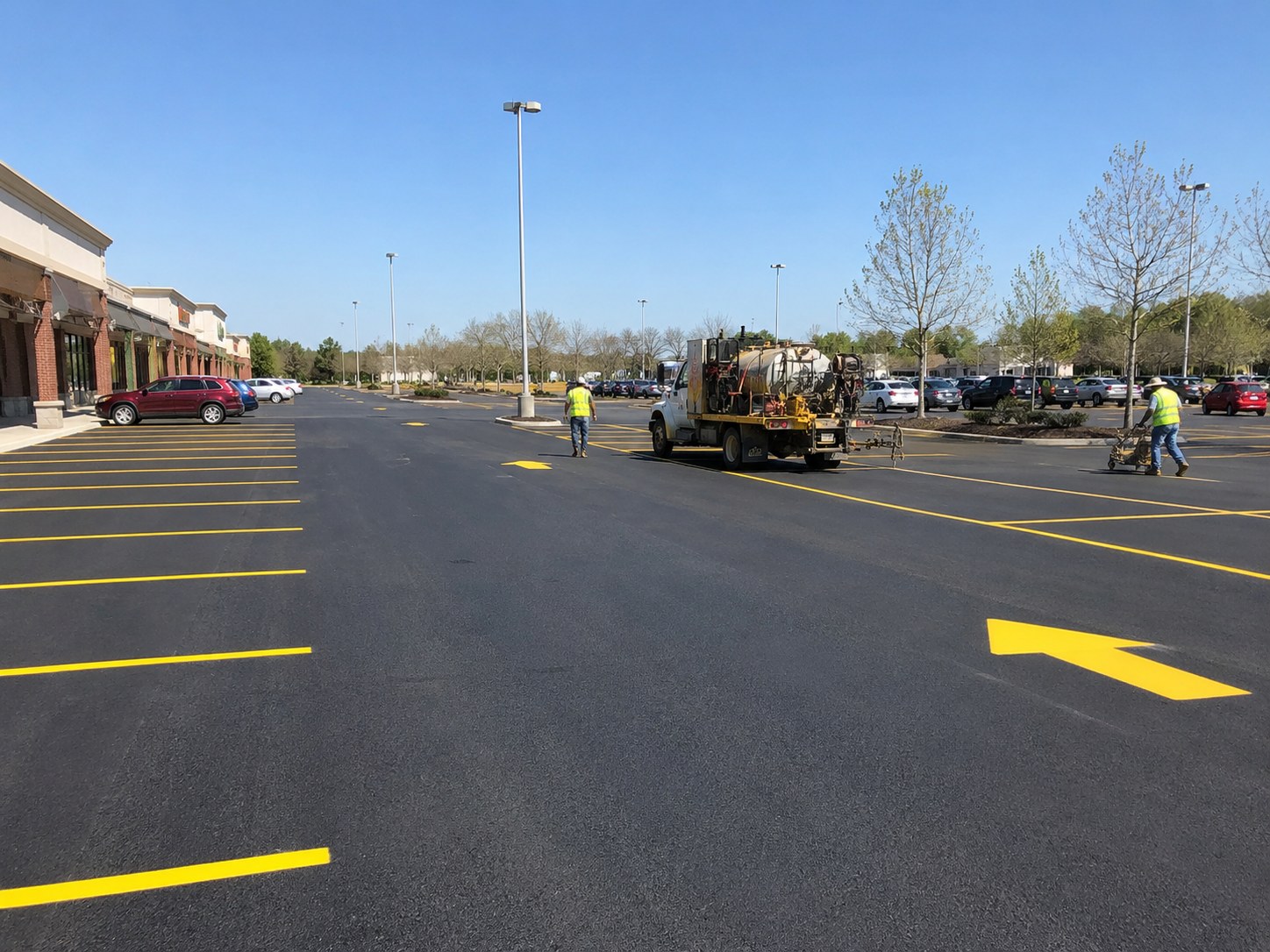 Commercial parking lot restriping project in Huntsville Alabama — fresh yellow lines and directional arrows